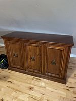 Front view showing three door panels and hardware