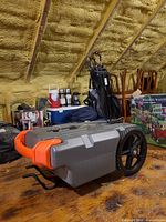 Top view of Camco Rhino portable waste tank showing orange handle and wheel assembly