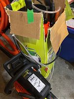 Chainsaw beside boxed sprayer showing both main items and tubing