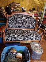 Front view of carved wood settee with zebra print upholstery