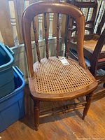 Full view of wooden side chair showing cane seat and turned legs