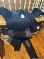 Front view of entire wetsuit draped over bench showing full length and front zipper