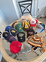 Group shot of 14 assorted caps and hats on table