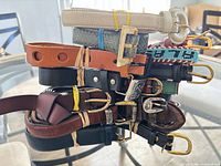 Stack of assorted belts showing materials, colors and buckle types