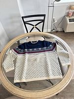 Full view of sweater front on table shows overall design, colors and condition