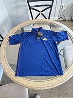 Full view of blue polo shirt laid flat
