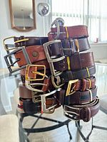 Stack of assorted belts showing variety of colours and buckles