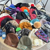 Wide view of approximately 30 assorted hats on table