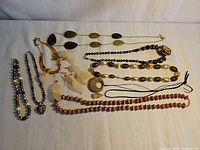 All nine necklaces laid out to show styles, colours and relative lengths