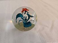 Full view of clear glass paperweight showing internal flower and butterfly