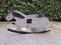 Left side view of wooden rocking horse showing dappled paint and rocker