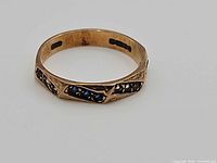 Oblique view of gold ring showing stone settings
