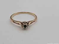 Top view of ring showing green center stone and diamond halo