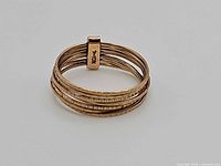 Ring showing seven hammered bands and keeper bar marked 10K