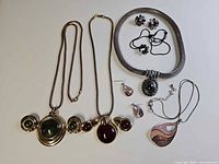 All jewellery pieces laid out - four necklace/earring sets plus one necklace visible