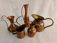All five copper and brass pitchers grouped