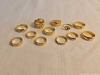 All twelve gold tone rings arranged on cloth surface