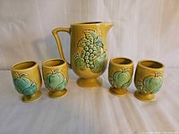 Pitcher with four matching pedestal glasses aligned