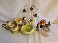 Group shot showing all ten items including platter, Beauceware bowl, cottageware set, glass barrel, teapot, pitcher and figurines