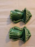 Front view of both green ceramic wall pocket vases showing design and glaze