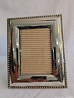 Front view of silver-tone frame with beaded border and neutral insert