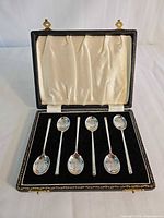 Open presentation case showing six sterling silver teaspoons in fitted interior