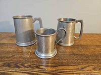 Three pewter mugs showing size comparison and handles