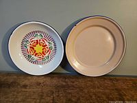 Front view of both enamelware dishes showing designs and color
