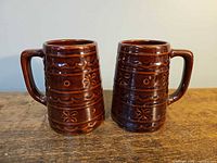 Pair of brown stoneware mugs showing size and pattern