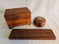 Group shot of cedar box, round Niagara Falls box, and cribbage board