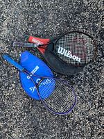 Both racquets with covers on asphalt surface