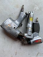 Two pneumatic air tools stacked showing overall appearance and fittings
