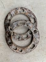 three rusted steel wheel spacers stacked