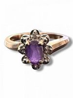Top view showing oval amethyst and diamond halo in floral cluster, gold band visible