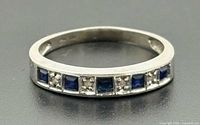 Front view of ring showing channel-set sapphires and diamonds