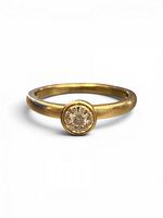 Ring front view showing bezel-set diamond cluster and polished gold band