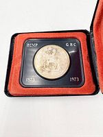 Obverse of coin in case showing mounted RCMP officer, date 1873-1973