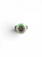 Top view of silver ring with jadeite disc and blue enamel flower