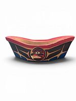 Front profile of carved wood canoe showing eagle crest and formline painting