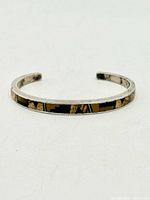 Oblique view of sterling cuff showing full geometric tiger's eye inlay band