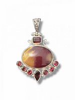 Front view of sterling silver pendant showing jasper cabochon, rectangular garnet, six round garnets, teardrop garnet and filigree bail