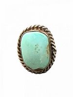 Top view of oval turquoise cabochon ring showing bezel and twisted rope border