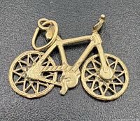 Front view of gold bicycle pendant showing detail