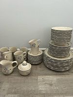 Stacked plates, cups, sugar bowl showing pattern and quantity