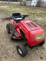 Full view of red MTD riding mower showing body, seat, deck and tires