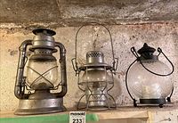 Front view of three lanterns on shelf