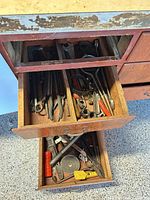 Two open drawers filled with assorted hand tools