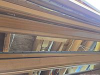 view of stacked stained wood trim pieces and metal door track overhead