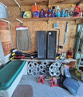 Wide view of shelf and all items including fluids, ramps, hubcaps, jack stands, lug wrench, brushes