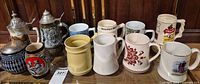 Group shot of all twelve mugs and steins on shelf